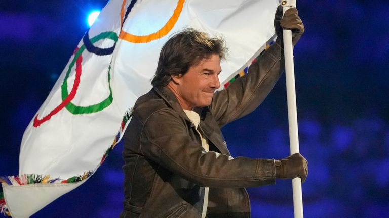 Tom Cruise carries the Olympic flag during the 2024 Summer Olympics closing ceremony at the Stade de France, Sunday, Aug. 11, 2024, in Saint-Denis, France. (AP Photo/Natacha Pisarenko)